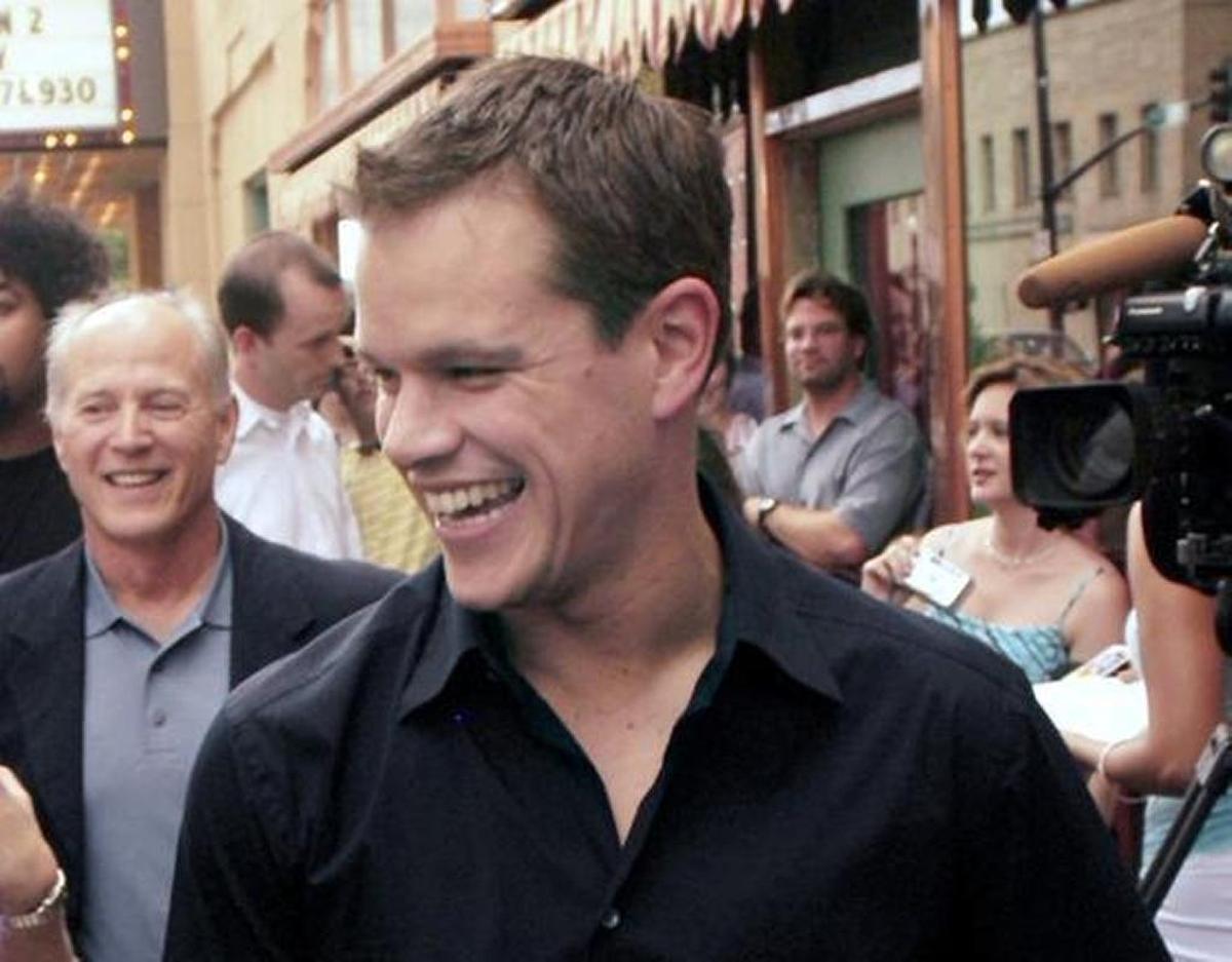 Matt Damon walks the red carpet Saturday night at the Egyptian Theatre in downtown Boise, appearing at an advance screening of his new film, "The Bourne Supremacy." Behind Damon at left is the film´s producer, Frank Marshall. (2004)