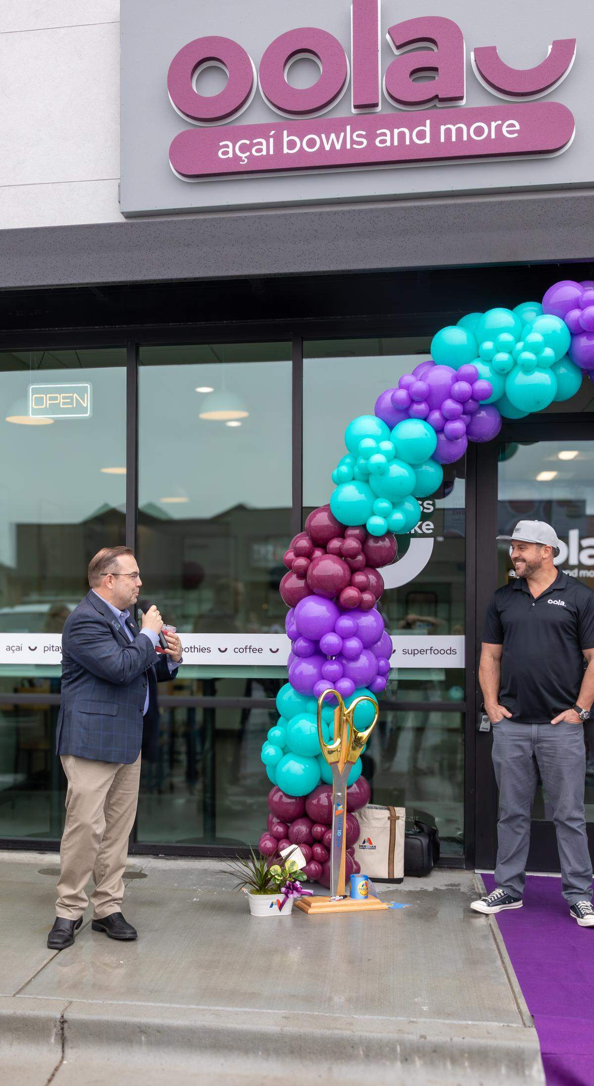 Oola Bowls local franchisee Mike Kahn, right, participates in a ceremony Wednesday at the Fairview store.
