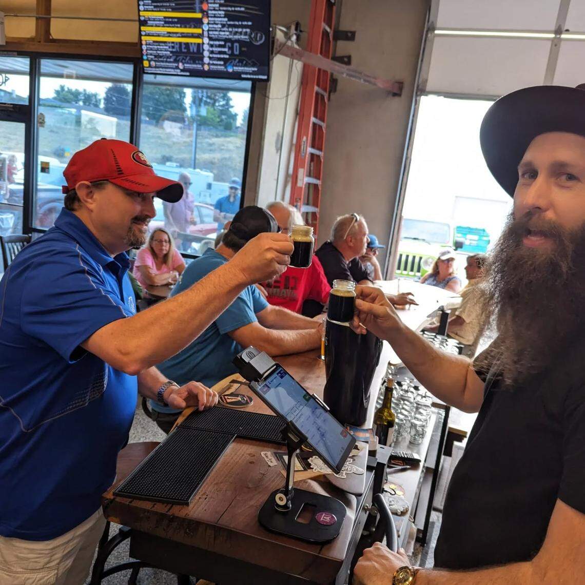 Brown Beard Brewing founder Bryce Tuttle, right, enjoys a sample of his own making at his original location.