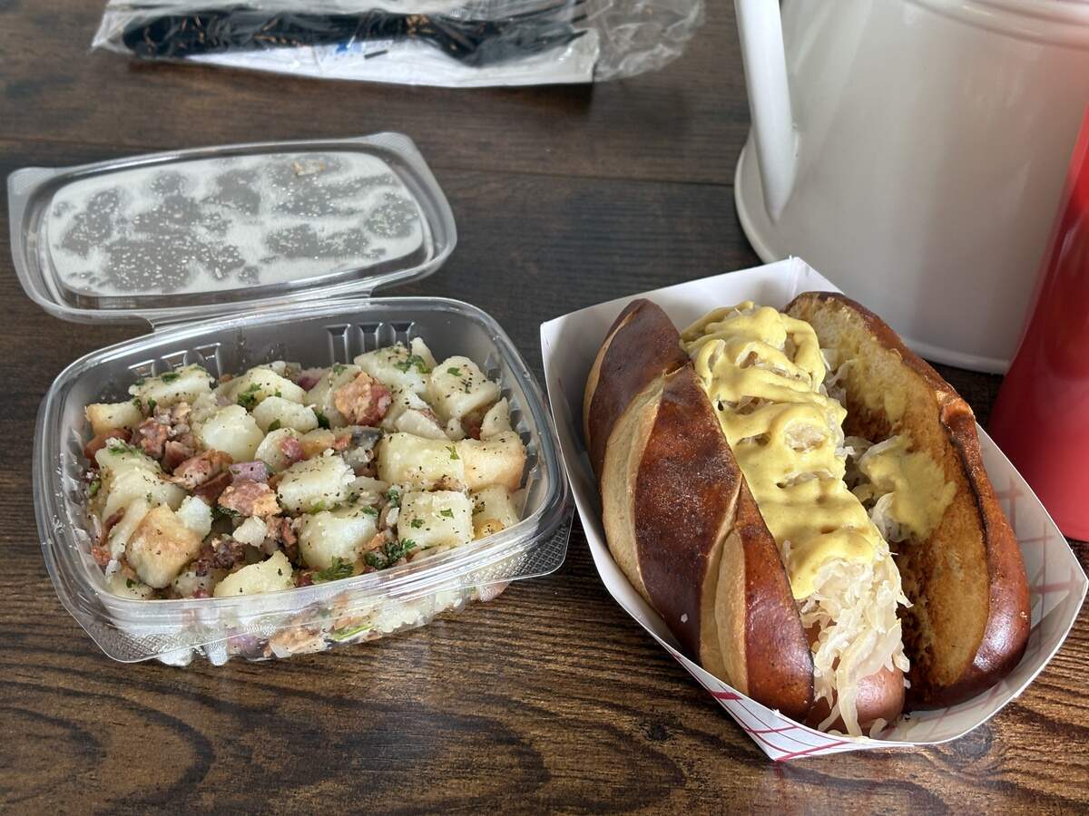 The beef bockwurst on a bun with a side of potato salad costs $12.