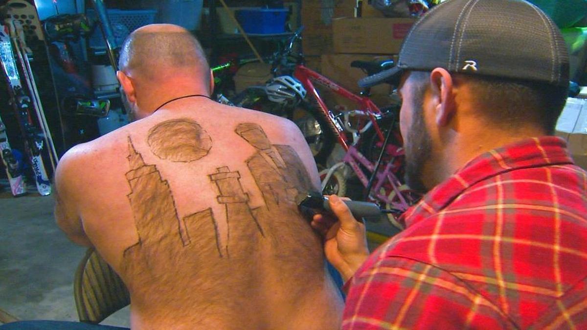 Tyler Harding, right, trims a design on Mike Wolfe out of his back hair in Nampa. The two men appeared on CBS last week to showcase their latest work.