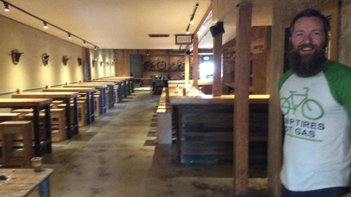 Ezra Jackson, owner of the HandleBar, standing inside the new bicycle-themed tavern earlier this month.