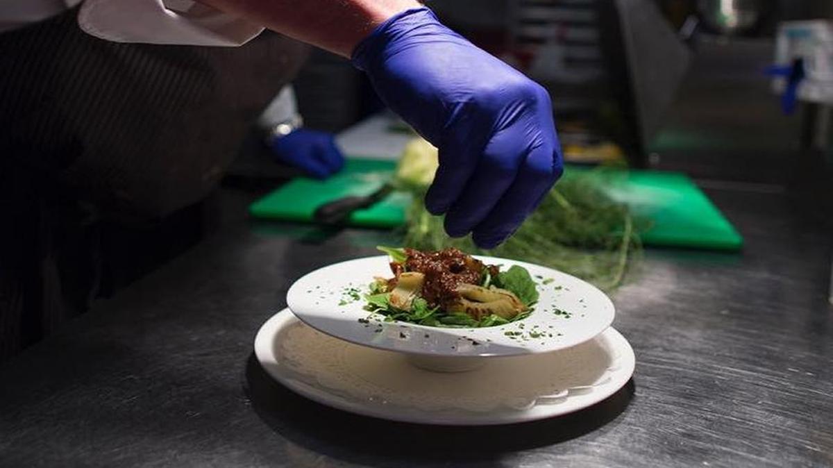 Chef David Williams prepares a salad at Le Coq d’Or.