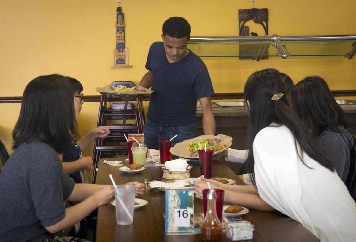A server delivers a dinner order to patrons at Kibrom’s Ethiopian and Eritrean Cuisine at 3506 W. State St. in Boise.