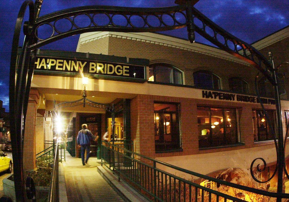 In this 2008 file photo, a person downtown walks toward Ha’Penny Bridge Irish Pub on 8th Street.