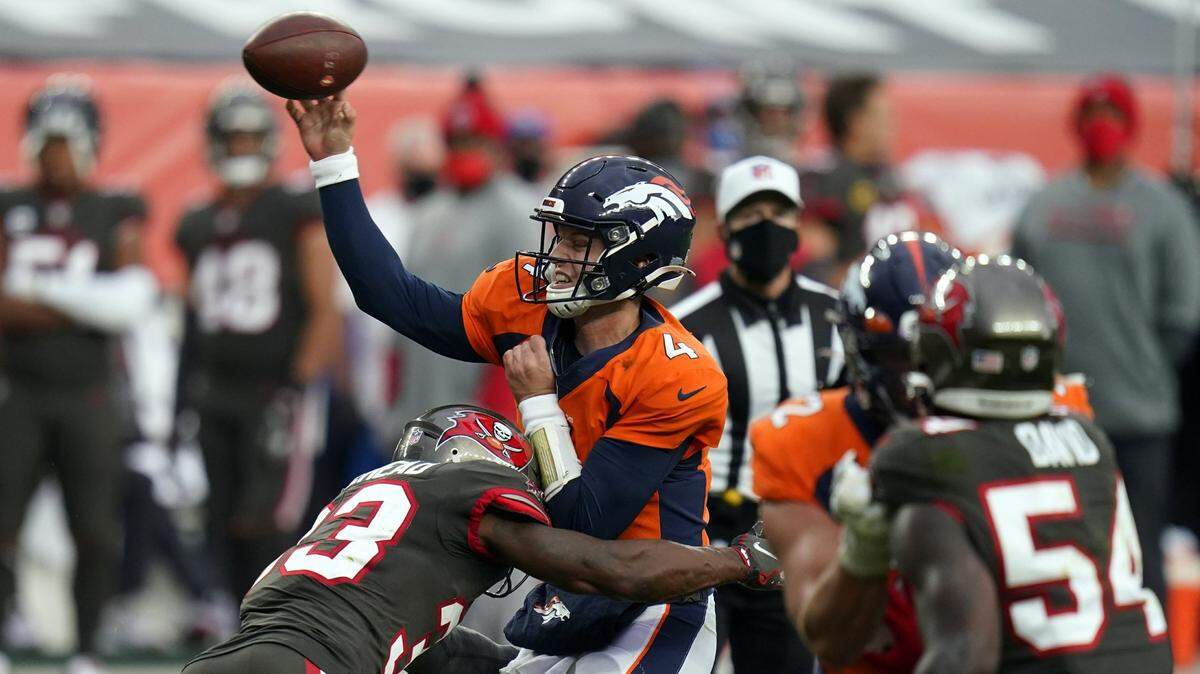 Denver Broncos quarterback Brett Rypien absorbs a hit as he delivers a throw during a game in 2020. Rypien is competing to back up Broncos quarterback Russell Wilson this season.