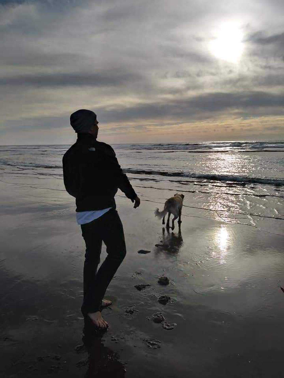 Melinda Lowe’s son walks on an Oregon beach last fall, with the family dog. The young man, who didn’t want to be named, has been diagnosed with mental illnesses, including schizophrenia. Lowe is trying to get him into a residential program on the East Coast that, unlike Idaho facilities, specializes in treating patients like him.