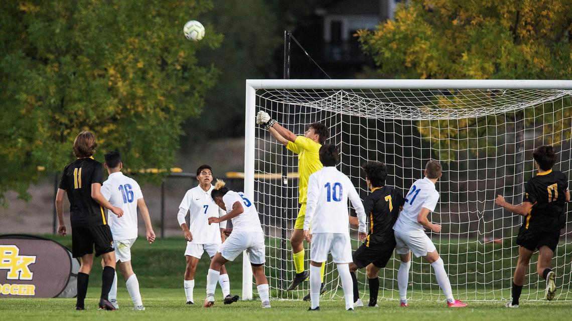 Caldwell goalie Greysen Porter punches away a cross Tuesday at Bishop Kelly.