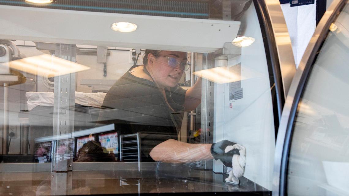 Andrea Garcia, of Idaho Meat and Seafood, cleans a butcher case, empty because customers are not allowed in the store. Garcia says that smaller butcher shops are having a harder time getting the quantities of meat they need, and the cost keeps going up. “We try not to scare people off, but we can’t help the prices,” she says.