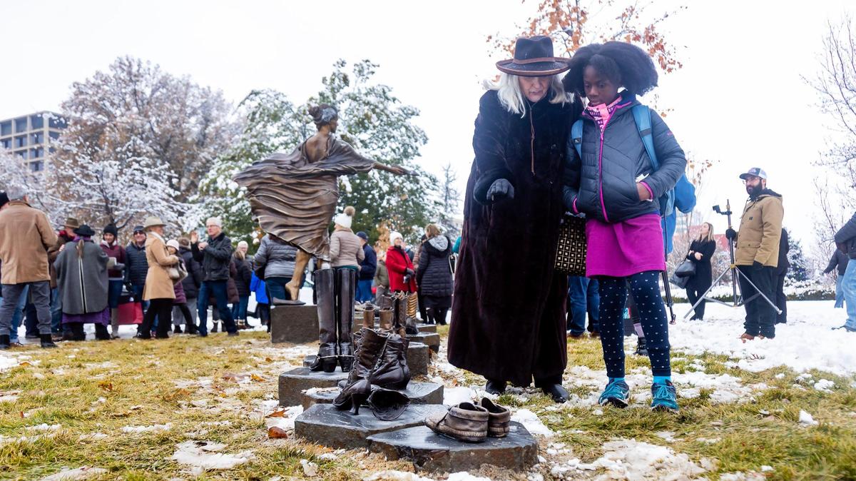 Dr. Carol MacGregor of Foundation for Idaho History explains to her granddaughter Cosette Wise, 9, the significance of the new statue by artist Irene Deely on the grounds of the Statehouse.