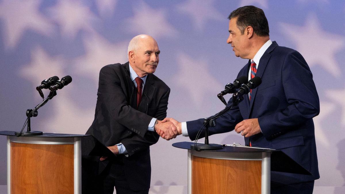 After an hour-long debate, candidates for Idaho Attorney General Tom Arkoosh, Democrat, and Raúl Labrador, Republican, shake hands as the event ends at Idaho Public Television, Monday, Oct. 3, 2022, in Boise.
