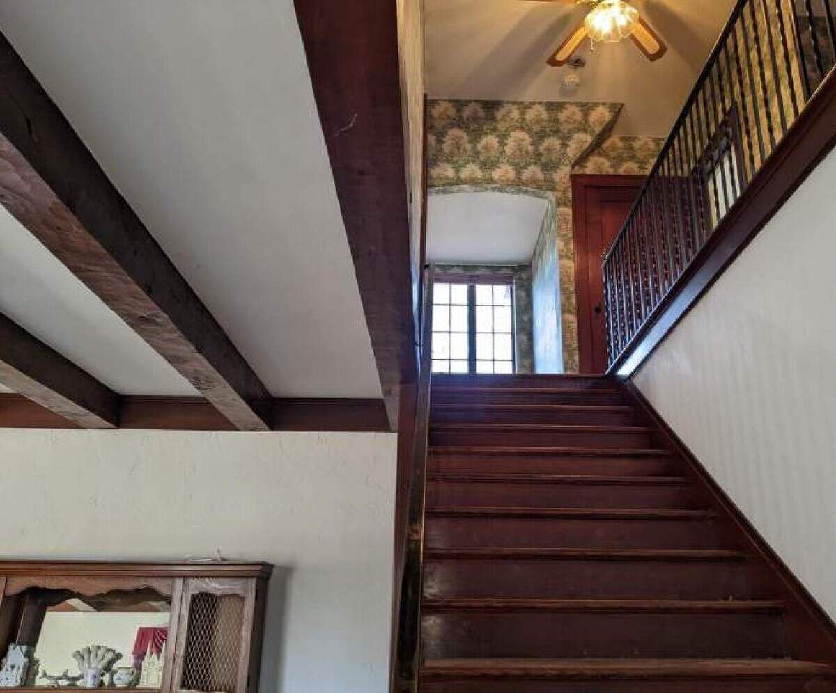 A hardwood staircase leads up from the main living room in 2024. Under the deed-restriction, which protects the home’s exterior, the city or a private owner would be able make changes to the interior of the house. Still, Eagle Museum Director Alana Dunn said she would “fight” to preserve certain features, including a wrought-iron banister at the base of the stairwell.