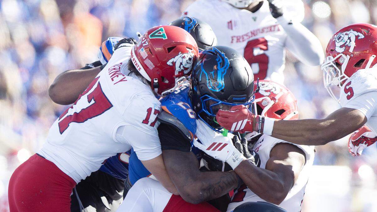 Boise State running back Sire Gaines gets stood up by Fresno State defensive back Ethan Tierney and nickleback Simeon Harris Fresno State leads Boise State 10-7 at the half of the game at Albertsons Stadium. November 1, 2025.