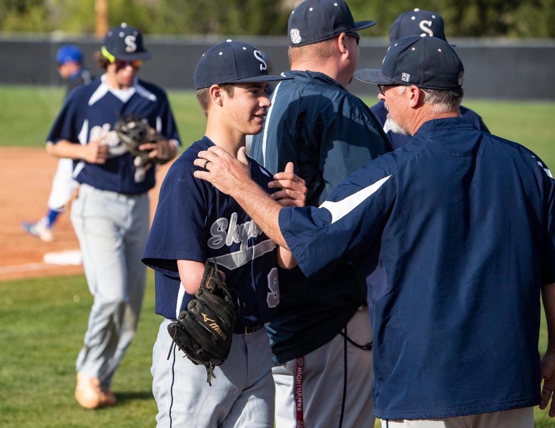 Skyview assistant coach Jay Lucas congratulates his son, Grayden Lucas, between innings Thursday at Skyview.