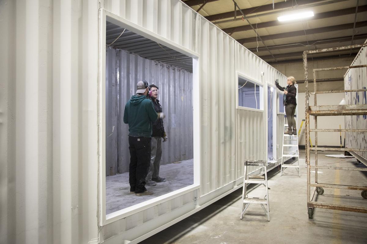 Autumn Munson, center, caulked the exterior frames of an IndieDwell home in the third stage of the production line. Stages one and two included cutting the openings for windows and doors and installing steel frames around them.