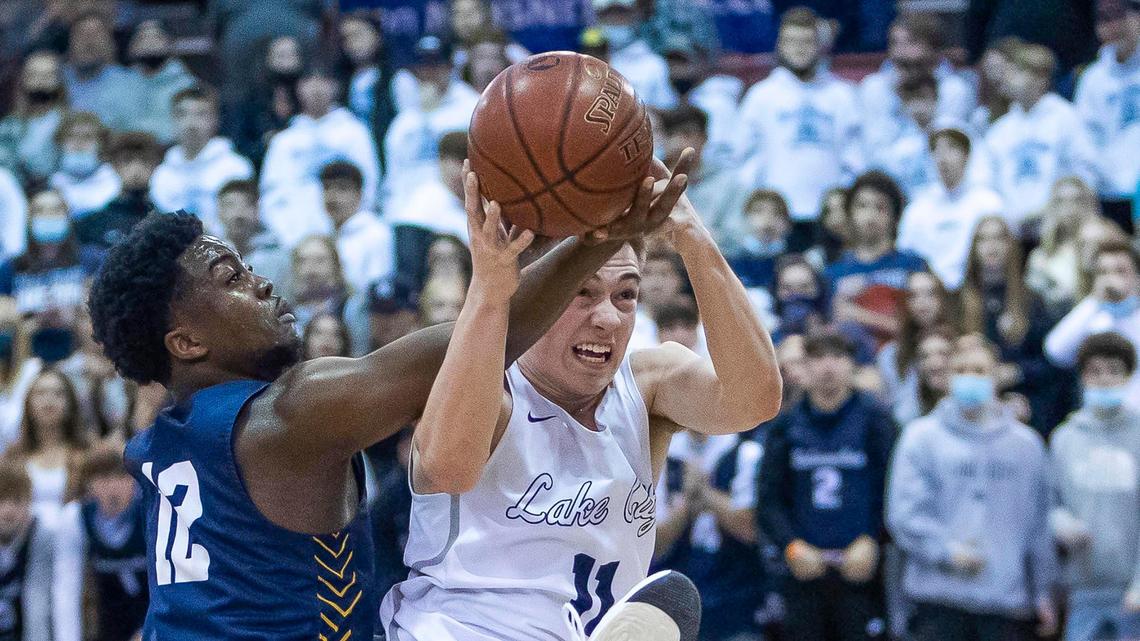 Meridian senior Joe Mpoyo battles for an offensive rebound with Lake City’s Zach Johnson in the 5A boys basketball state championship Saturday at the Ford Idaho Center in Nampa.