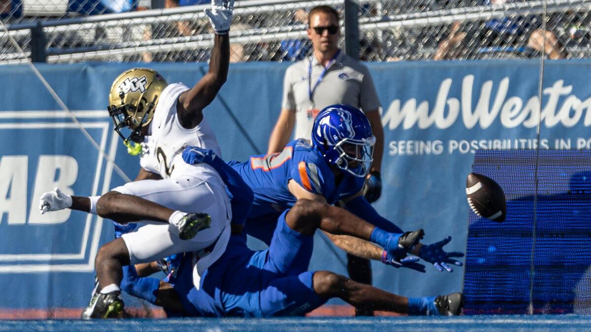 Boise State safety Alexander Teubner dives to intercept a deflected pass intended for UCF wide receiver Kobe Hudson on the game’s opening drive Saturday.