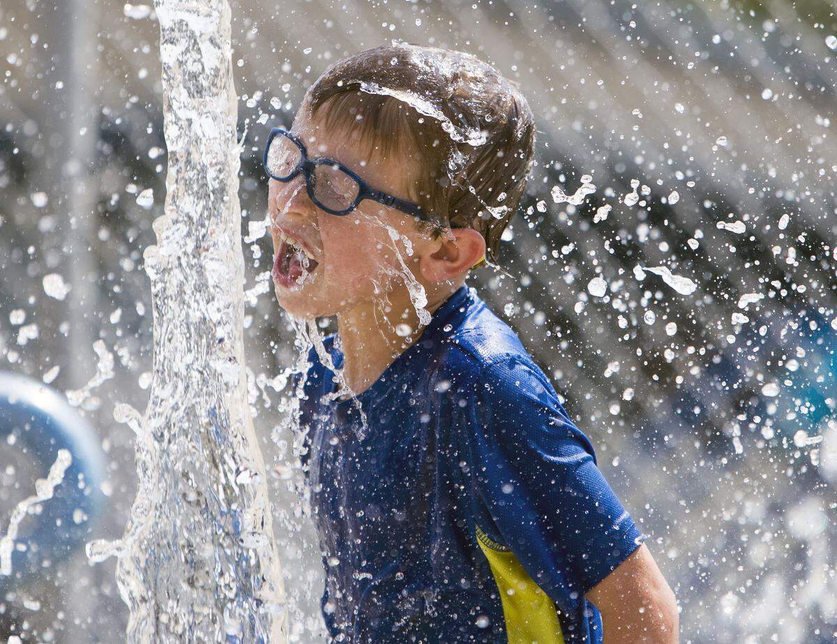 Elijah Holfeltz, 8, cools off with a splash at the children’s water playground at Borah Pool in Boise Friday, Aug. 10, 2018. 