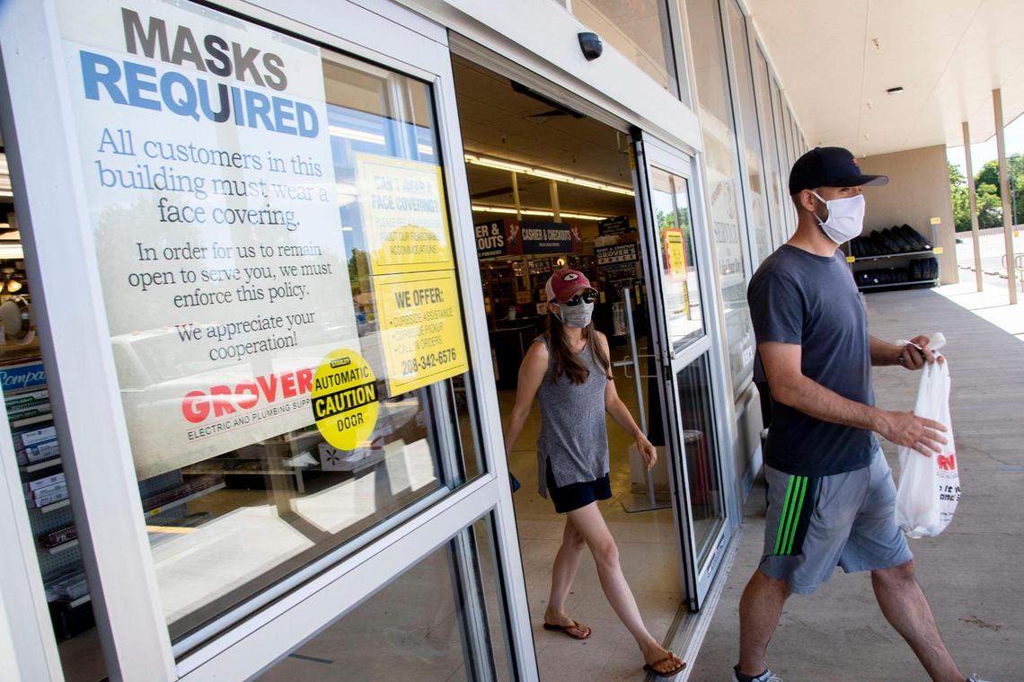Lee and Lori Johnson, Boise, exit through the automatic sliding doors at Grover’s Pay & Pack Electric and Plumbing in Boise on Saturday. Customers are met with a notice saying “masks required” before entering the store. Employees also wear protective masks.