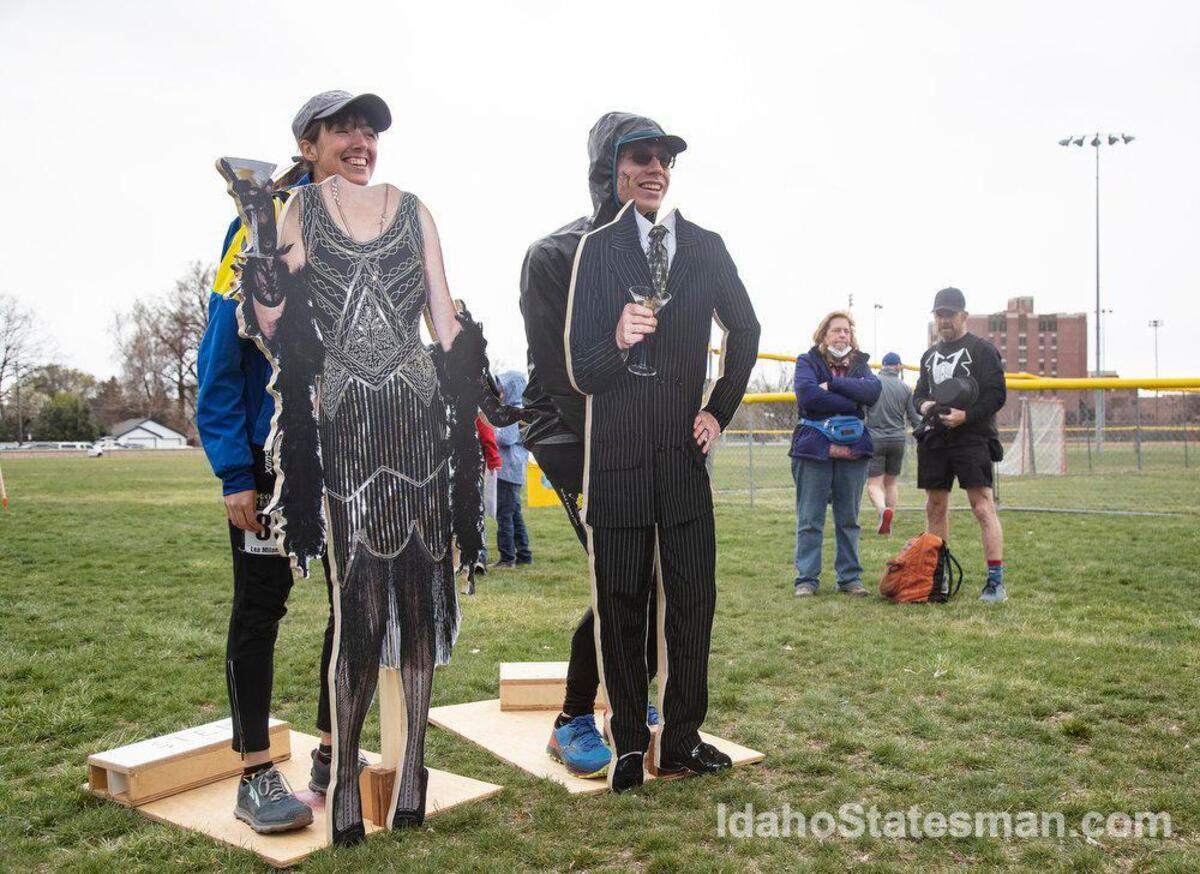 Runners Lea Milando and Nick Care stand behind cutouts of 1920s themed characters before the Race to Robie Creek half marathon on Saturday, April 26, 2022.