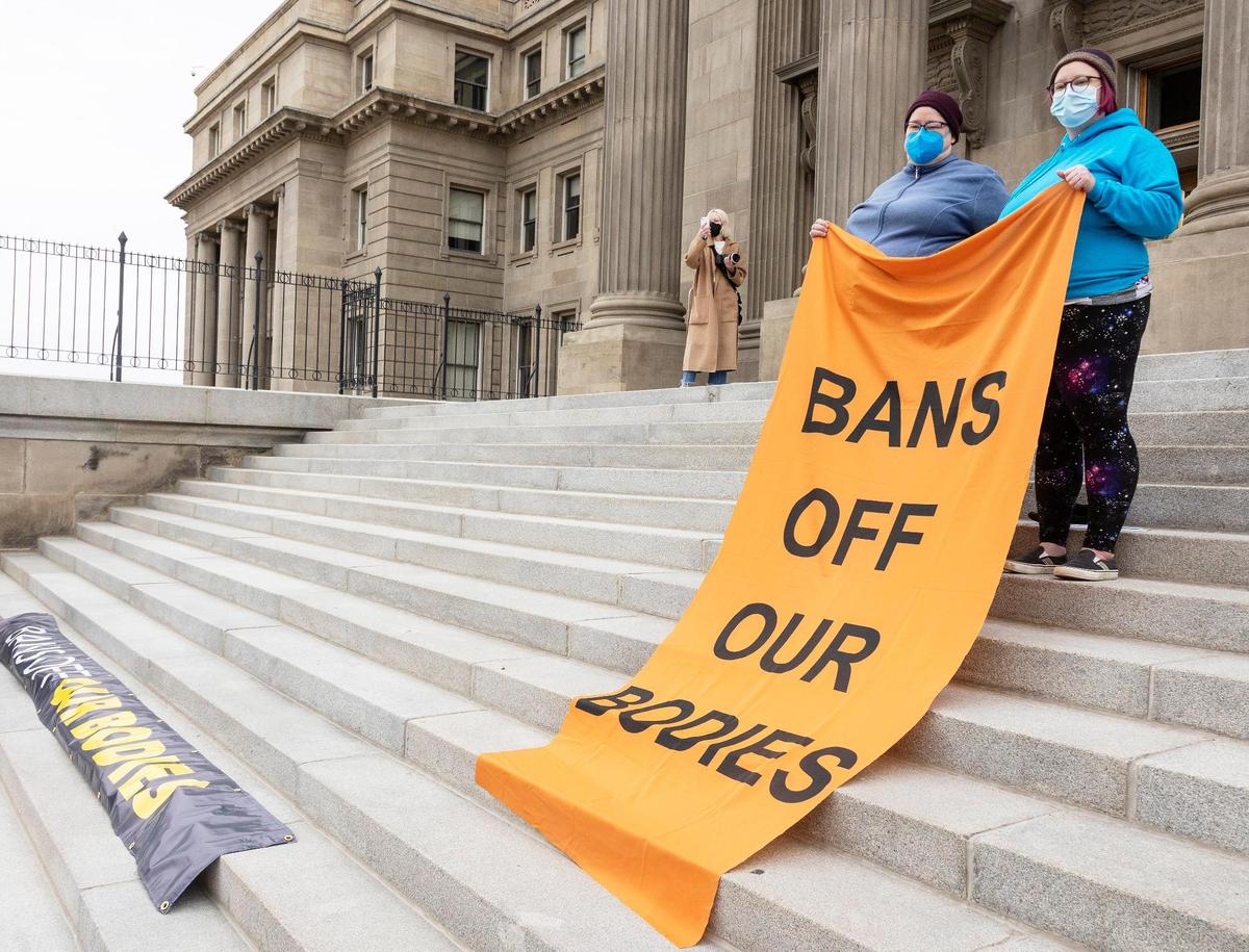 Neysa Jensen of Boise and her daughter Emily Jensen hold a banner reading “bans off our bodies” while standing on the steps of the Idaho Capitol Building during a protest of Senate Bill 1309 held on March, 19, 2022. The law would ban abortion after around 6 weeks and uses a civilian enforcement mechanism in an effort to circumvent legal challenges.
