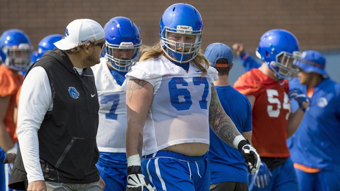 Boise State center Garrett Larson talks with offensive line coach Brad Bedell during the first practice of fall camp on Aug. 3 at DeChevrieux Field. Larson is a three-year starter for the Broncos.