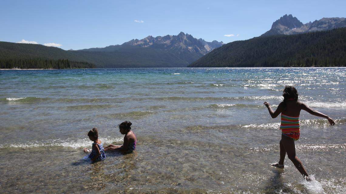 Children play in the crystal-clear waters of Redfish Lake at the base of the Sawtooth Mountains in central Idaho. A planned 4.4-mile trail connecting the lake to Stanley is being challenged in federal court.
