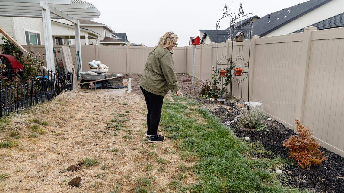 Montgomery points to where her backyard has continued to flood.