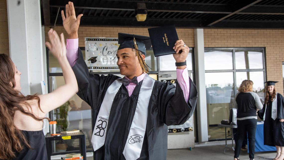 Newly graduated Trevor Hale exchanges congratulations with his family at Capital High School’s drive-in graduation. Spaced and paced alphabetically, seniors got to walk across a stage individually, witnessed by family members. “Even though it was not the traditional one,” Hale said, “it’ll be (a graduation) I remember forever.”