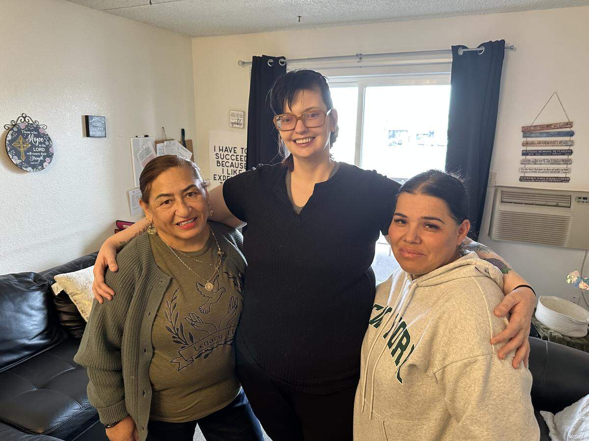 Katie Hodges, center, stands in the living room of her Nampa apartment on Feb. 13, with Angelita Martinez, left, and Veronica Medina, of Legacy ResHab Services, which has helped Katie live on her own and out of Idaho institutions for the past four years.