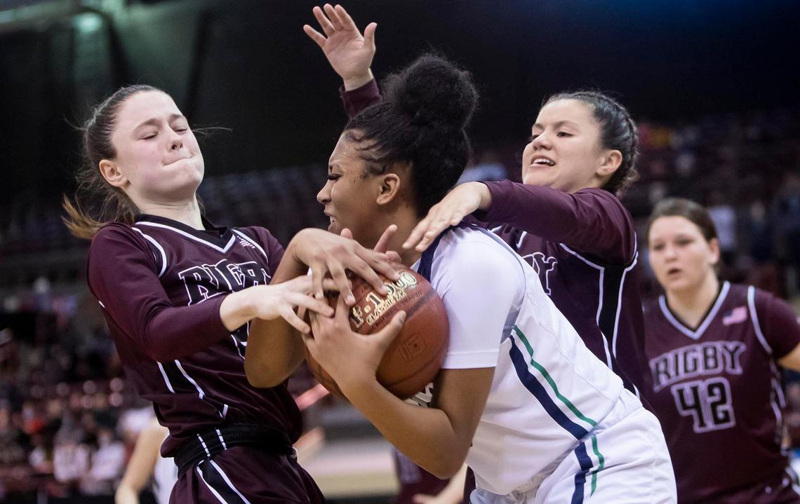 Mountain View guard Demi Thompson ties up a ball with two Rigby defenders during the 5A state semifinals last season.