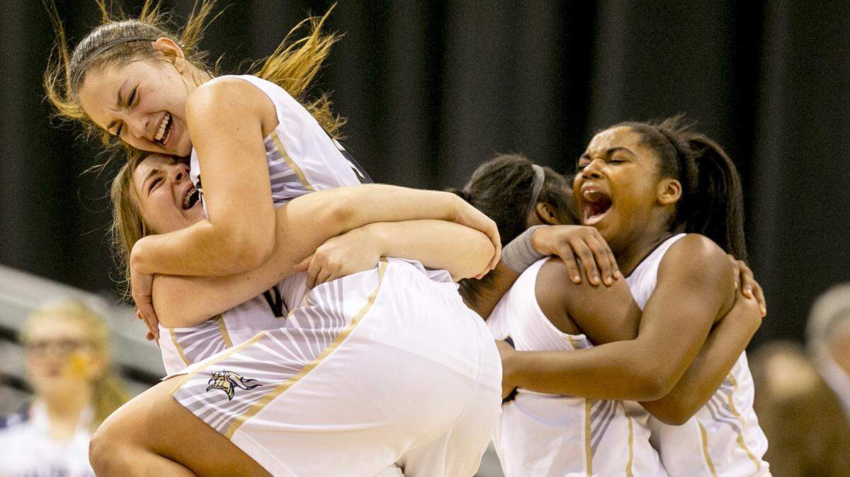 Middleton’s Lexi Mitchell jumps into the arms of a teammate after winning the 2017 4A state championship.