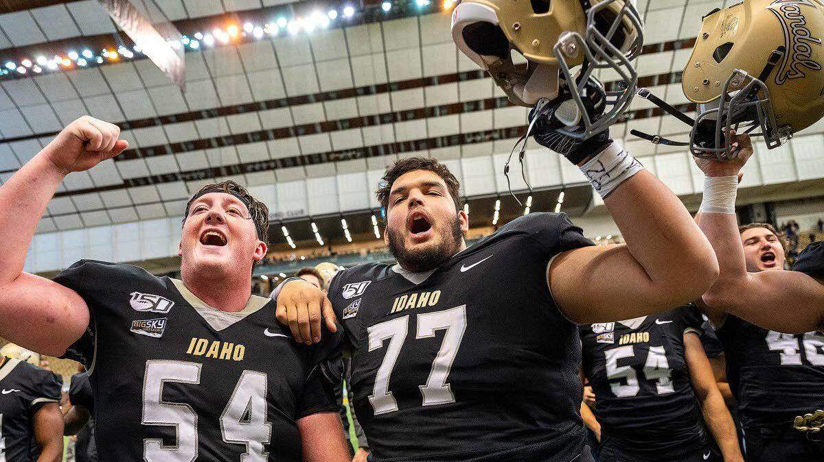 Idaho offensive linemen Logan Floyd (left) and Brian Robinson sing the Vandals’ fight song after beating Cal Poly on Nov. 2 at the Kibbie Dome.