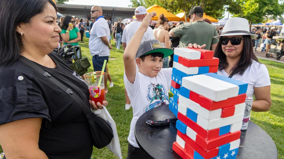 Aiden Flores, 9, center, plays a game at the inaugural Viva Nampa Festival at Lloyd Square Park in downtown Nampa, Friday, June 27, 2025. The event was a collaboration between the 208 Night Market and the Downtown Nampa Association.