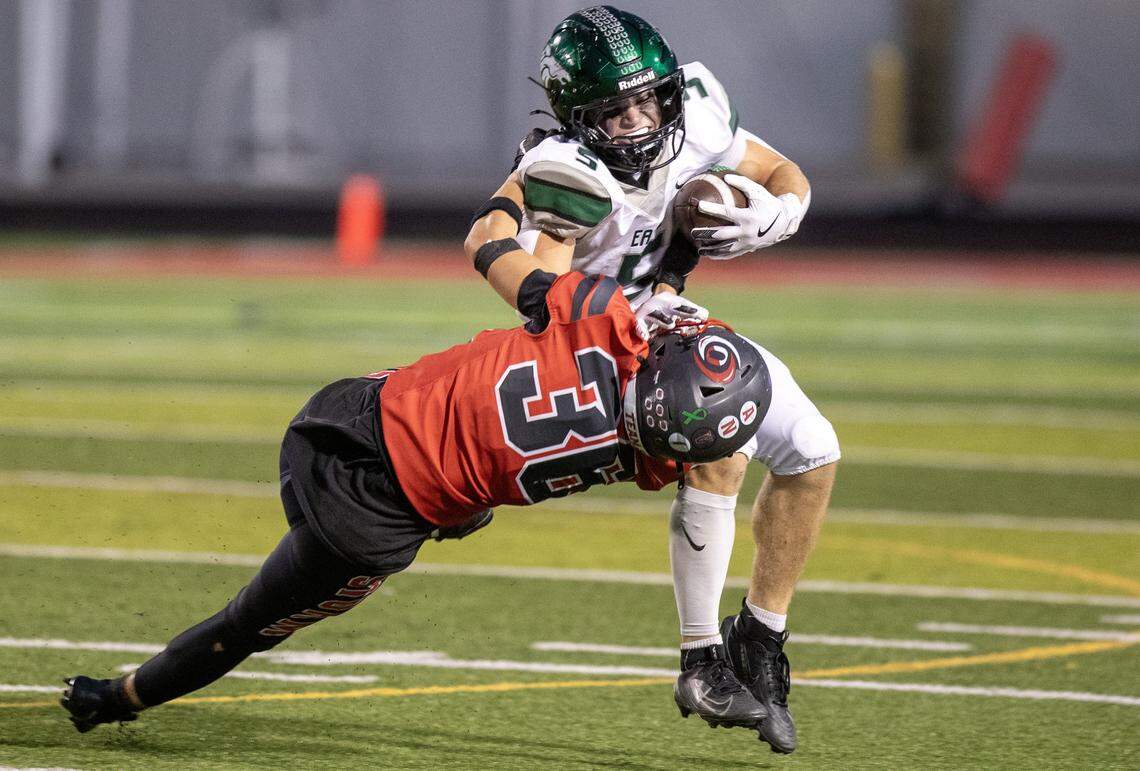 Eagle running back Luke Mikita stiff arms and breaks the tackle of Owyhee player linebacker Jonah Swallow at Owyhee High School in Meridian, Oct 3, 2025
