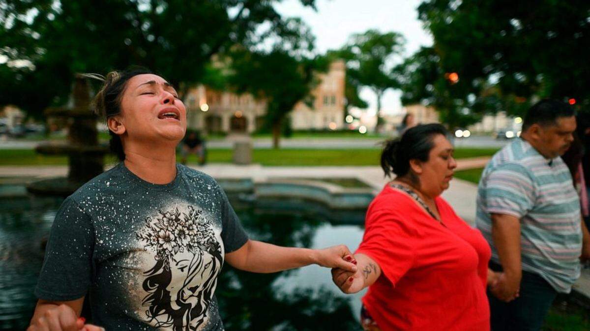 Families mourn outside Robb Elementary School in Texas on Tuesday evening.