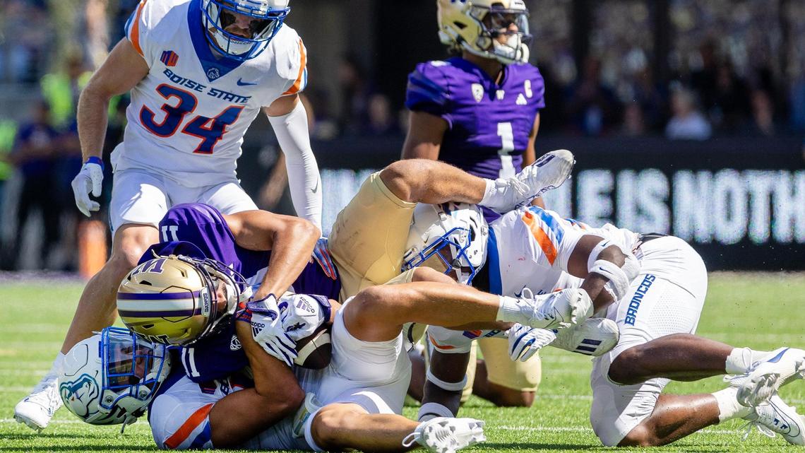 Boise State cornerback Kaonohi Kaniho and safety Seyi Oladipo bring down Washington wide receiver Jalen McMillan after a long gain Saturday at Husky Stadium in Seattle. The Huskies’ high-powered passing game was too much for the Broncos.
