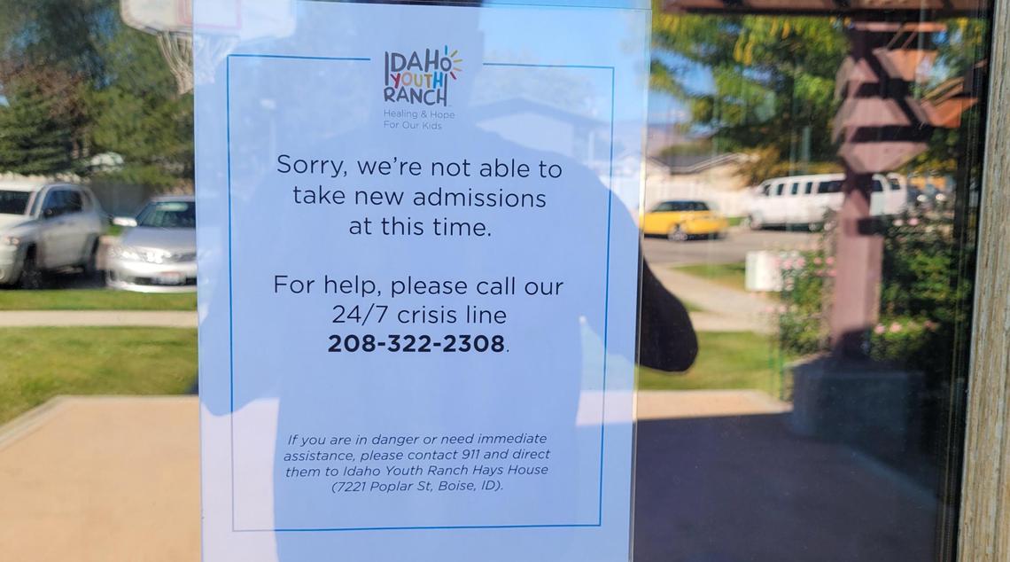 A sign on the door at the Hays House youth shelter says it is not taking any new placements. The shelter needs to hire a dozen staff members before it can open again.