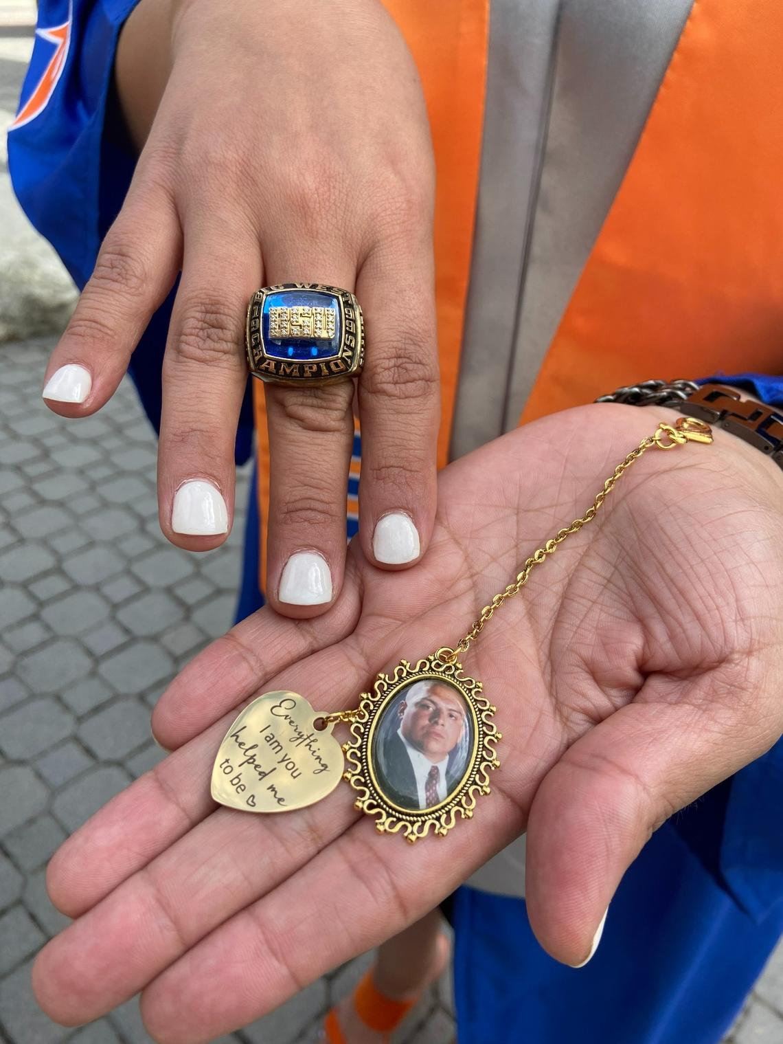 Former Boise State defensive lineman Paul Reyna’s sister, Ryann Gusman-Reyna, shows off a locket and Reyna’s 1999 Western Athletic Conference championship ring. She plans to wear both during her graduation ceremony on Saturday.