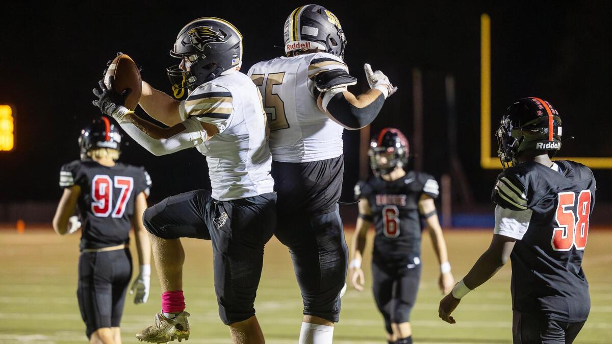 Kuna running back Austin Lattimer, left, and offensive lineman Gavin Hindle, right, celebrate a Lattimer touchdown Friday at Dona Larsen Park.