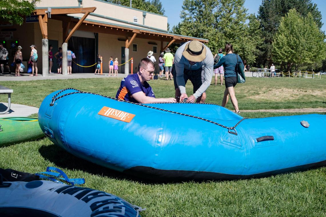 Douglas White and Adam Eldred inflate a large raft they brought themselves to Barber Park on Saturday, June 26, 2021. Increased traffic at the Boise River Float put-in at Barber Park has led to the city enforcing no parking on neighborhood streets as well as encouraging people to park at Ann Morrison Park and take the shuttle to Barber Park.