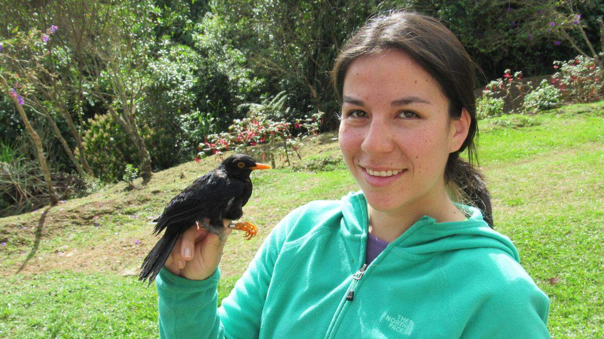 Natalia Gutierrez Pinto shows off the first bird she captured for her doctoral dissertation in the mountains of Colombia.