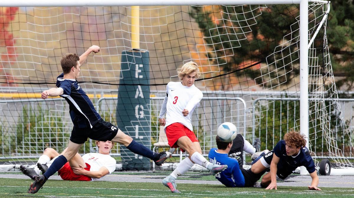 Boise’s Cory Cadwell, center, clears the ball after teammate Jack Montgomery, left, and keeper Arthur Langlet land on the ground after a shot by Lake City’s Kohrt Weber during the 5A boys soccer state semifinals Friday at Eagle High School.