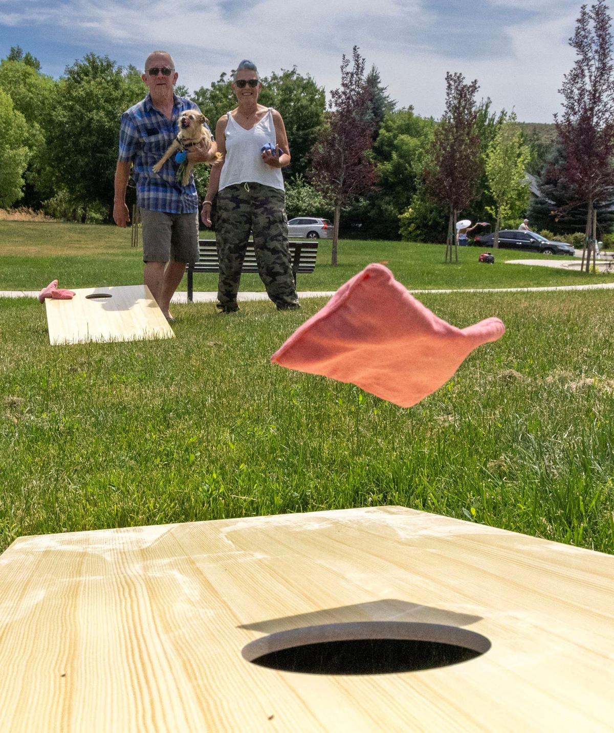 Ric and Regina Smith, and Betty their dog, play a round of cornhole at the Central Foothills Neighborhood Association party.