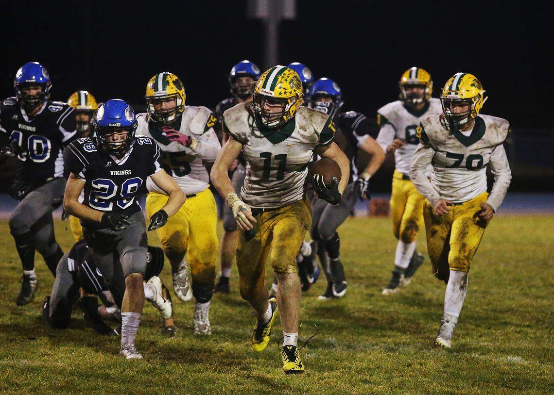 Borah’s Austin Bolt runs the ball as Coeur d’Alene defenders try to chase him down Friday night in the 5A state quarterfinals in Coeur d’Alene. The Vikings won 37-34.