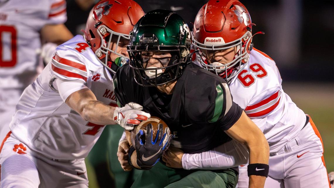 Eagle sophomore Luke Mikita tries to fend off tackles from Madison’s Payson Genta and Tegan Mortensen (69) last week. The Mustangs (8-2) travel to Coeur d’Alene (8-2) for a 6A state semifinal Friday looking to avenge a loss to the Vikings in the same round last year.