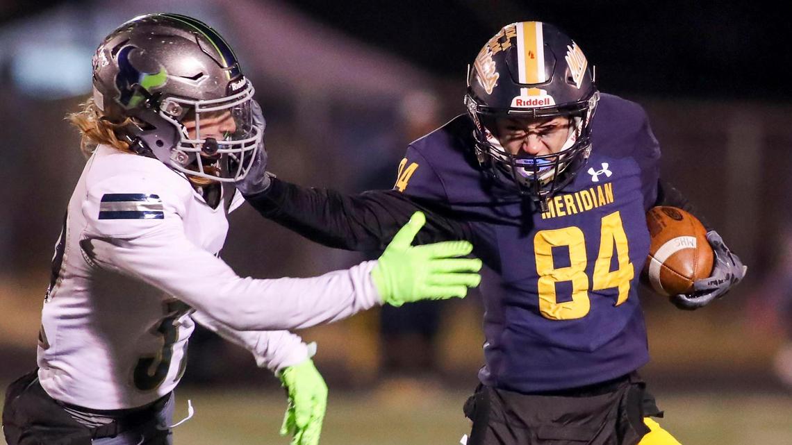 Meridian wide receiver Tyson Acree stiff arms Mountain View’s Caden Connors during the Warriors 34-10 win in the 5A state semifinals Friday at Meridian High.