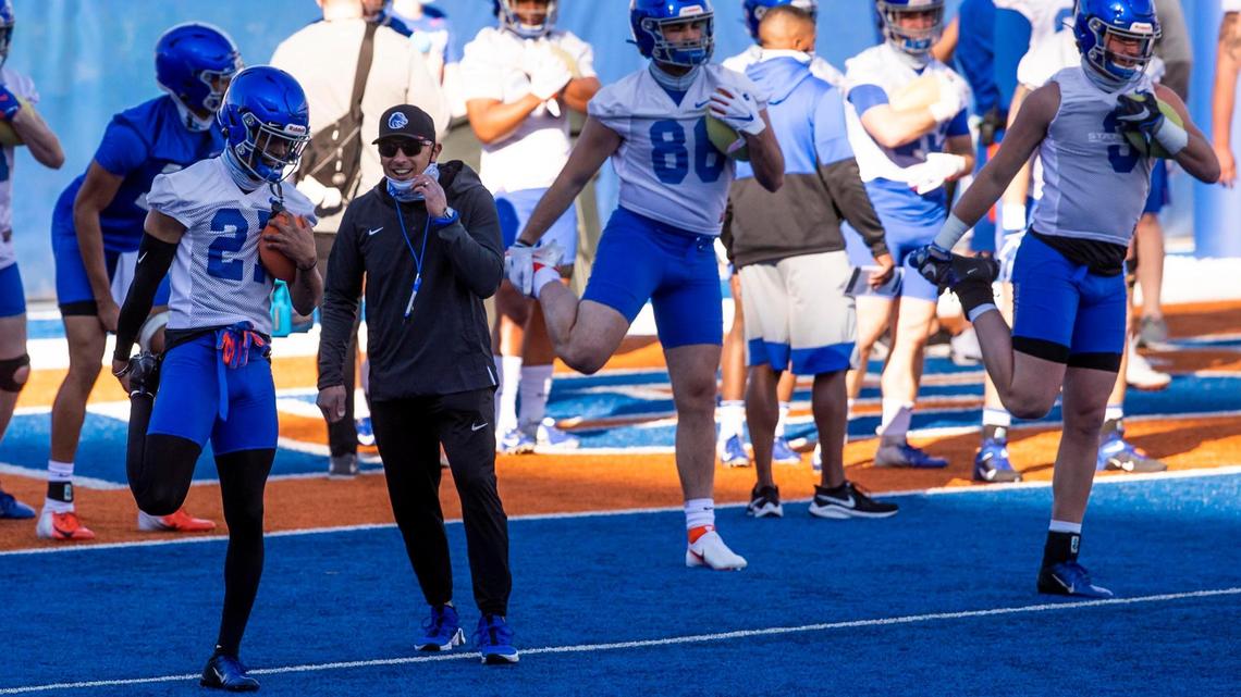 Boise State head football coach Andy Avalos talks with wide receiver Shea Whiting as the Broncos warm up for their first spring practice on March 12.