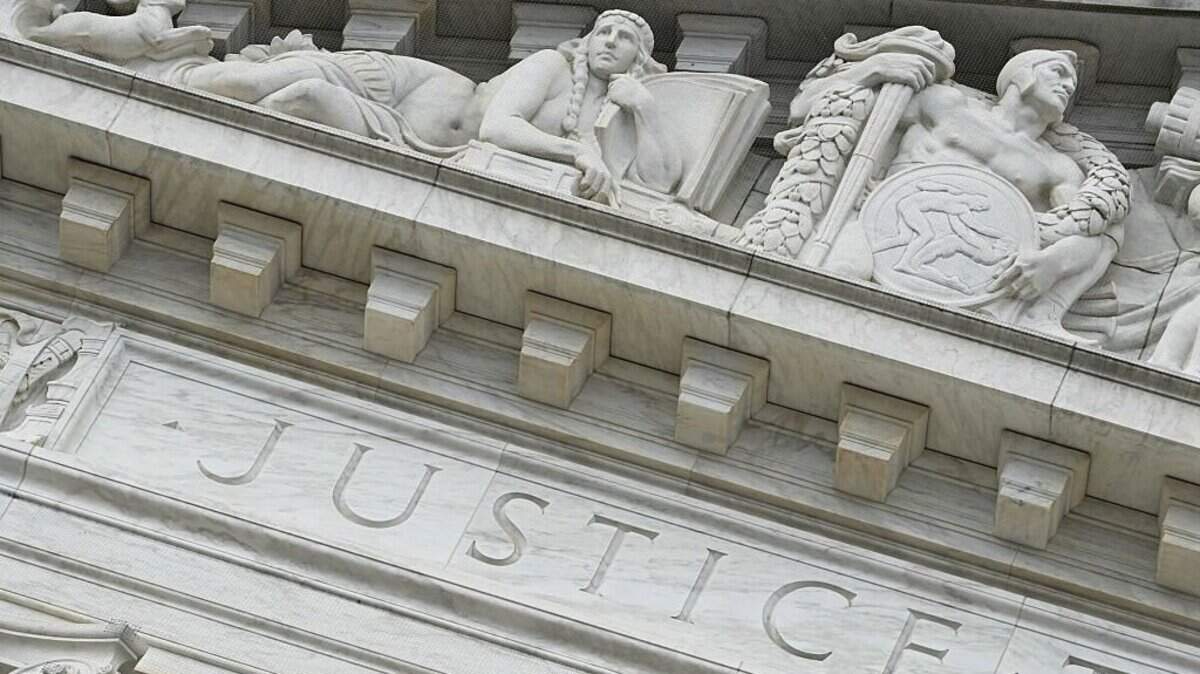 The word "Justice" is seen on the rear side of the US Supreme Court as the Court hears arguments in the case over President Donald Trump's dismissal of Federal Trade Commission (FTC) commissioner Rebecca Slaughter last March in Washington, DC, on December 8, 2025. The case is being closely watched due to its broader implications concerning President Trump's powers to fire the heads of independent government agencies. (Photo by Jim WATSON / AFP via Getty Images)