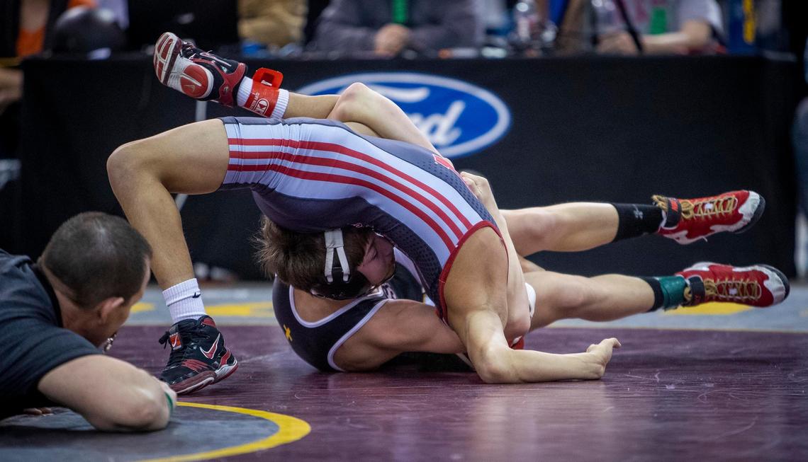 Bishop Kelly’s Christopher Martino tallies points on a nearfall of Simon Alberto, Nampa, during the 4A 106-pound state wrestling championship Saturday, Feb. 29, 2020 at Ford Idaho Center in Nampa. Martino won the title.